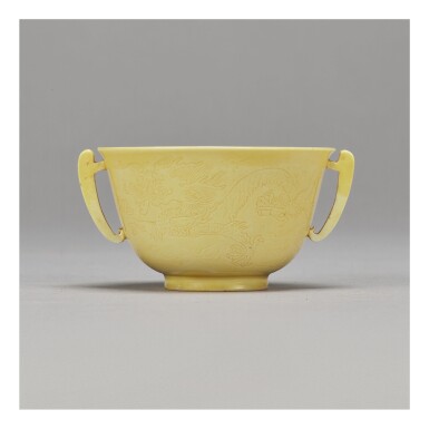 View full screen - View 1 of Lot 101. A FINE INCISED YELLOW-GLAZED 'DRAGON' HANDLED CUP, KANGXI MARK AND PERIOD.