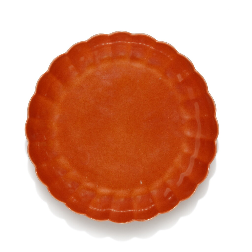 View full screen - View 1 of Lot 54. A coral-red enamelled 'chrysanthemum' dish, Mark and period of Yongzheng, possibly later enamelled | 清雍正 後施珊瑚紅彩菊瓣盤 《大清雍正年製》款.