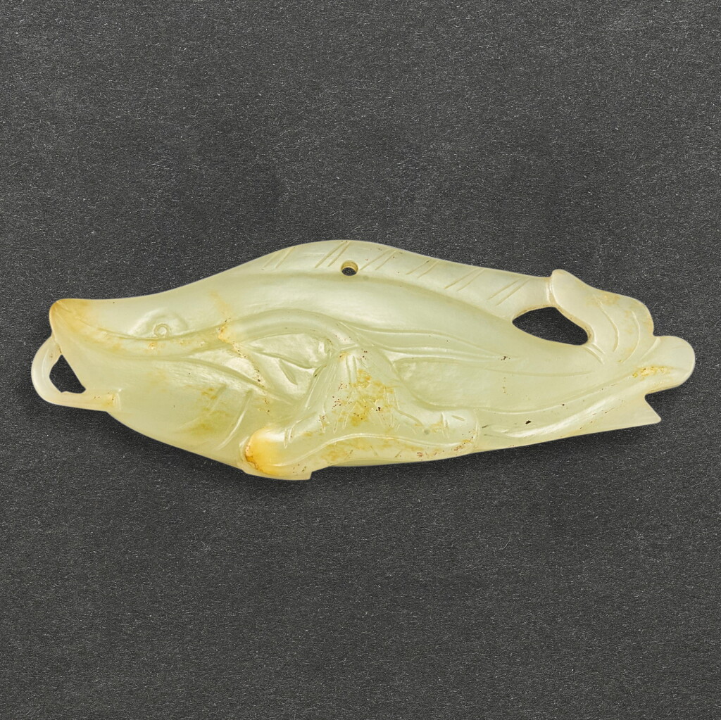 View full screen - View 1 of Lot 570. A CELADON JADE 'FISH AND LOTUS' PENDANT QING DYNASTY | 清 青白玉鯰魚荷花珮飾.