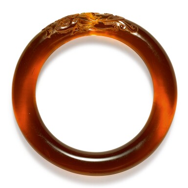 View full screen - View 1 of Lot 265. An amber bangle, Qing dynasty, 18th century | 清十八世紀 琥珀雕瑞獸銜芝紋鐲.