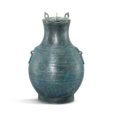 View full screen - View 1 of Lot 3038. An archaic bronze wine vessel and cover, Hu, Warring States period | 戰國 青銅弦紋舖首活環耳蓋壺.
