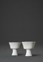 A fine pair of white-glazed 'phoenix' stem cups, Marks and period of Yongzheng | 清雍正 白釉暗花鳳穿牡丹紋高足盃一對 《大清雍正年製》款