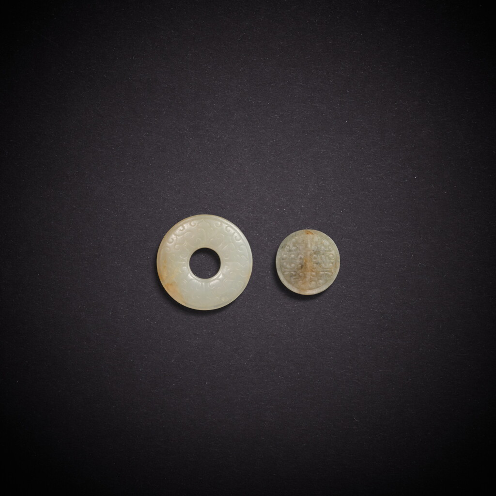 View full screen - View 1 of Lot 5812. A white jade ring and a celadon jade circular pendant, Eastern Zhou dynasty, Warring States period | 東周戰國 白玉環及青玉圓形墜.