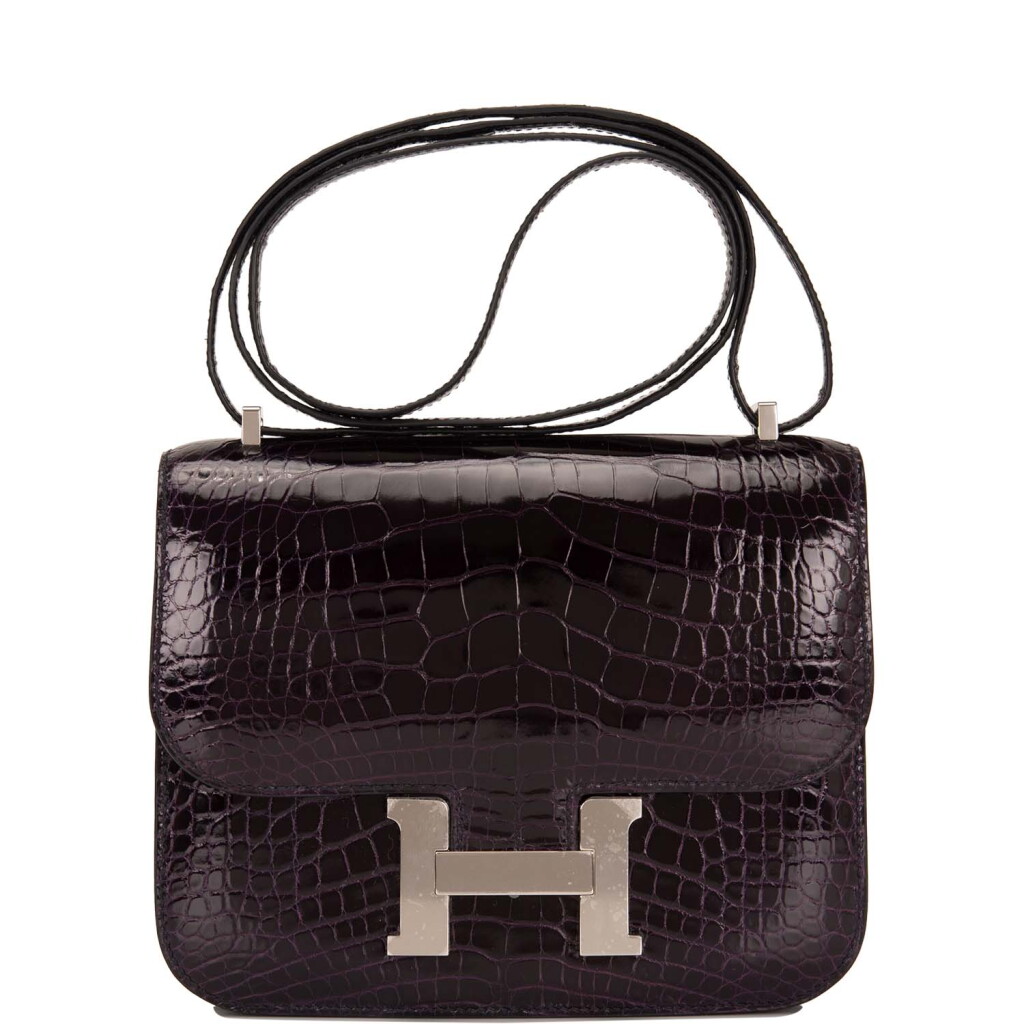 View full screen - View 1 of Lot 71. HERMÈS | AUBERGINE MINI CONSTANCE 18CM IN SHINY MISSISSIPPIENSIS ALLIGATOR WITH PALLADIUM HARDWARE.