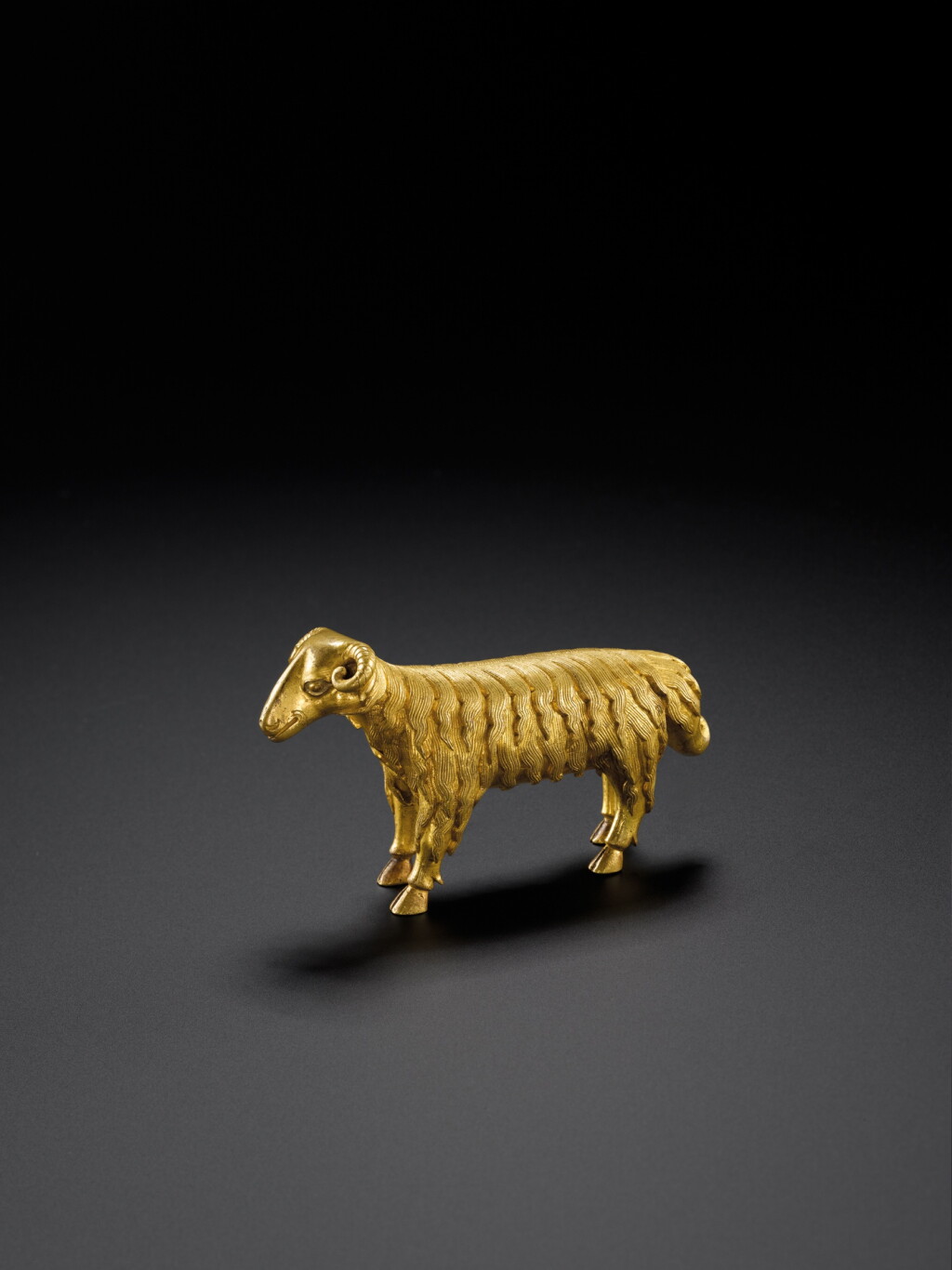 View full screen - View 1 of Lot 120. A gilt-bronze figure of a ram, Ming dynasty, 15th century | 明十五世紀 鎏金銅立羊.