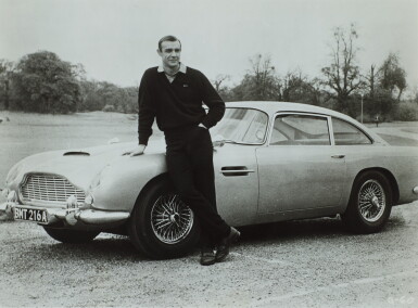 View full screen - View 1 of Lot 70. Sean Connery with Aston Martin DB5 During the Filming of 'Goldfinger', Stoke Park (horizontal).