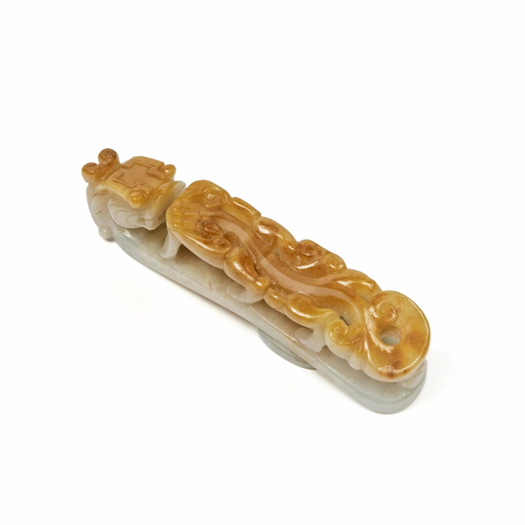 View full screen - View 1 of Lot 656. A white and russet jadeite 'chilong' belt hook, Qing dynasty, 19th century | 清十九世紀 翡玉雕螭龍紋帶鉤.