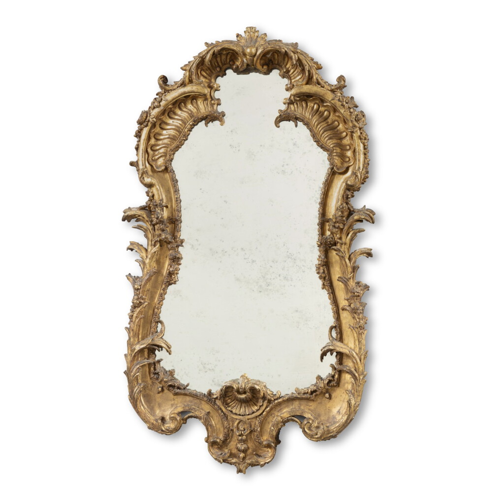 View full screen - View 1 of Lot 45. A carved giltwood and gesso wall mirror, possibly North European, mid 18th century | Miroir sculpté en bois doré, peut-être Europe du Nord, milieu du XVIIIe siècle.