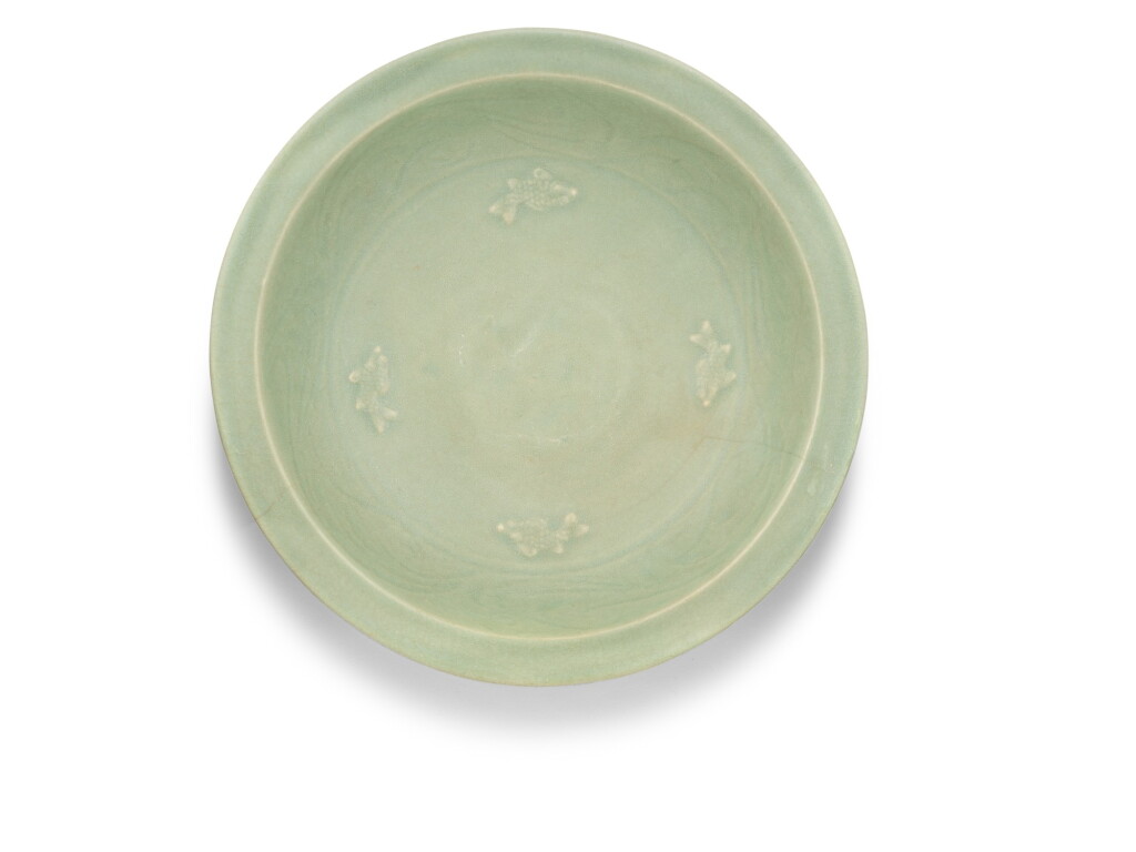 View full screen - View 1 of Lot 16. A large Longquan celadon 'fish' dish, Early Ming dynasty | 明初 龍泉青釉貼花魚紋折沿盤.