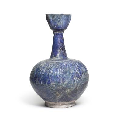 View full screen - View 1 of Lot 30. A Kashan blue-glazed moulded pottery bottle vase, Persia, 12th century.