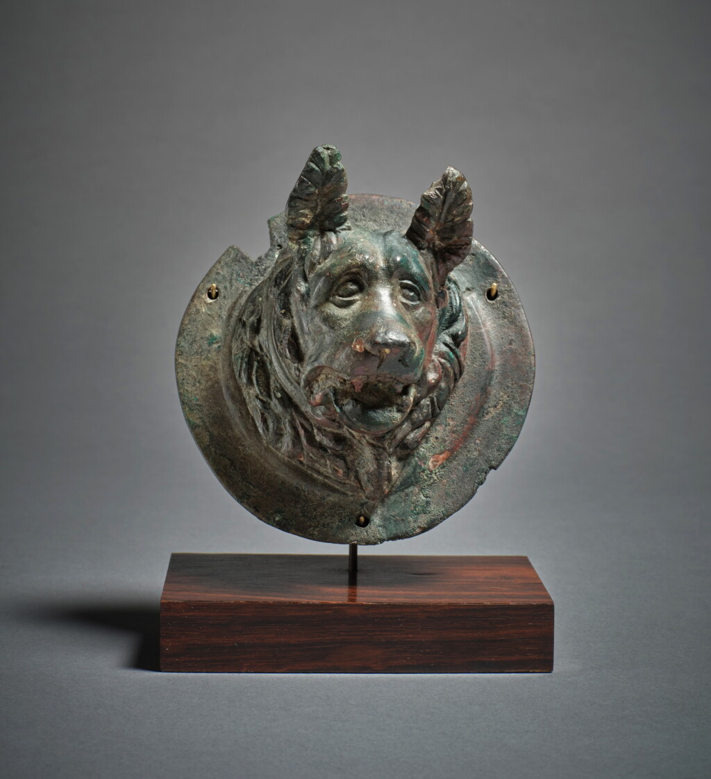 View full screen - View 1 of Lot 103. A Roman Bronze Roundel with a Relief Bust of a Molossian Hound, circa 1st/2nd century A.D..
