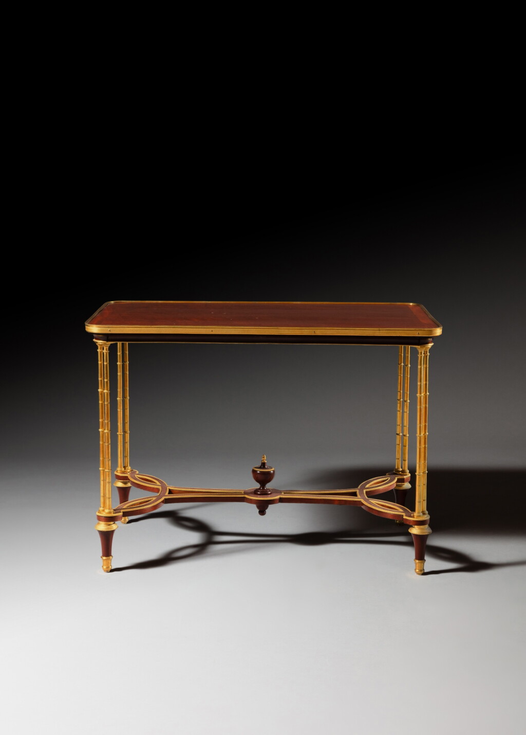 View full screen - View 1 of Lot 52. A Louis XVI gilt-bronze mounted plum-pudding mahogany and mahogany veneered center table, circa 1780, attributed to Adam Weisweiler .
