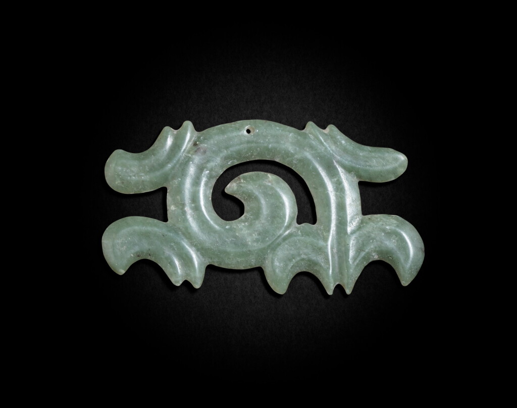 View full screen - View 1 of Lot 82. A pale green jade 'cloud-shaped' pendant Neolithic period, Hongshan culture | 新石器時代 紅山文化青玉勾雲形珮.