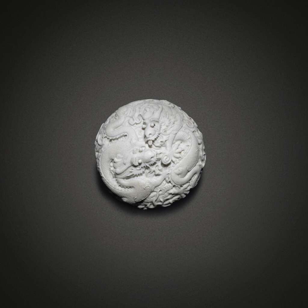 View full screen - View 1 of Lot 583. A carved biscuit 'dragon' box and cover, Late Qing dynasty / Republic period | 清末 / 民國 素胎雕瓷雲龍戲珠紋蓋盒 《大清乾隆年製》仿款.