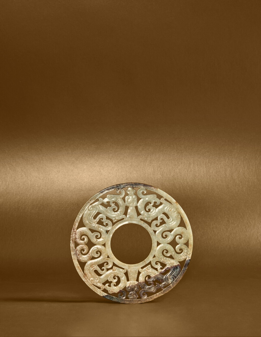 View full screen - View 1 of Lot 111. A rare carved and reticulated jade 'dragon and human' disc (Bi), Eastern Zhou dynasty, Warring States period.