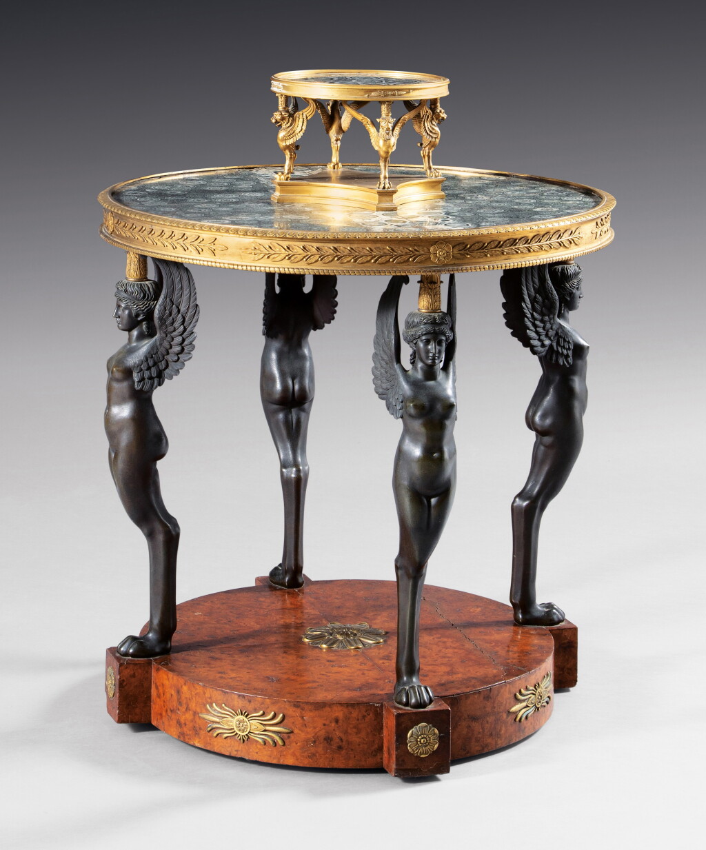 View full screen - View 1 of Lot 18. A patinated and gilt-bronze mounted burr amboyna guéridon attributed to Pierre-Philippe Thomire, Consulat, late 18th century | Guéridon en bronze patiné, doré et placage de loupe d'amboine d'époque Consulat, attribué à Pierre-Philippe Thomire, fin XVIIIe siècle.