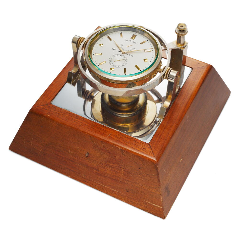 View full screen - View 1 of Lot 253. A gilt brass display deck chronometer with 50-hour power reserve indication and a wooden base, Circa 1950.