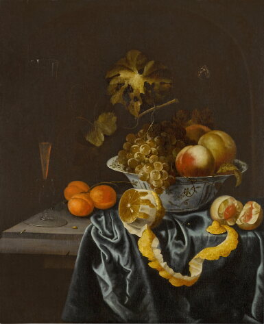 View full screen - View 1 of Lot 338. Still life of a porcelain bowl with peaches and grapes, a peeled lemon, apricot, and a façon de Venise wine glass on a partially draped stone ledge.