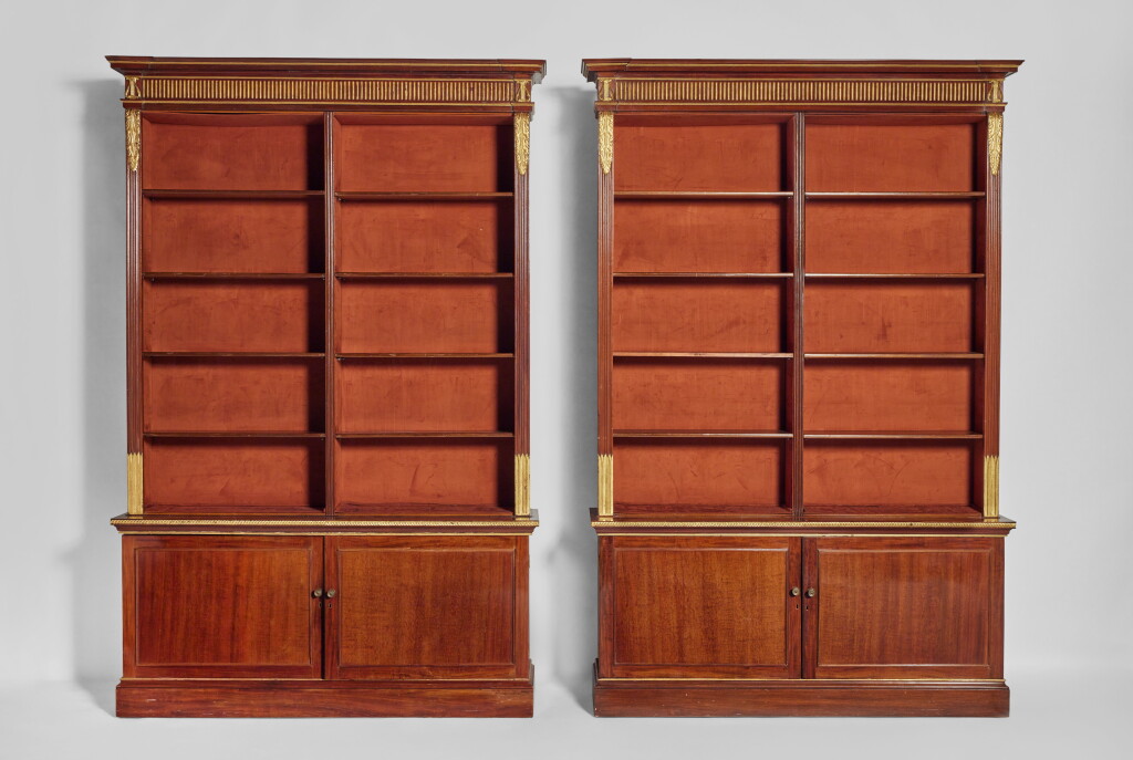 View full screen - View 1 of Lot 398. A Pair of Regency Style Parcel-Gilt Mahogany Bookcases.
