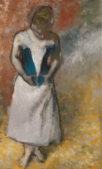 Femme debout et vue de face agrafant son corset