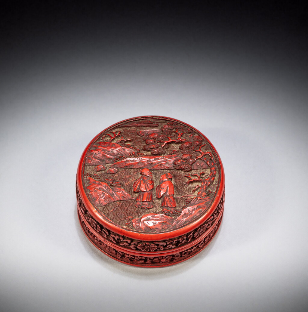 View full screen - View 1 of Lot 153. A small carved cinnabar lacquer 'figural' circular box and cover, Mark and period of Qianlong | 清乾隆 剔紅人物故事圖蓋圓盒 《 大清乾隆年製 》《仙侣寳盒》款.