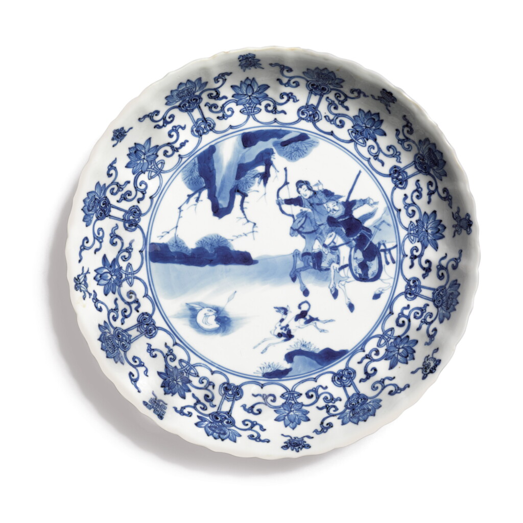 View full screen - View 1 of Lot 833. A BLUE AND WHITE 'HUNTING' BARBED-RIM DISH, QING DYNASTY, KANGXI PERIOD.