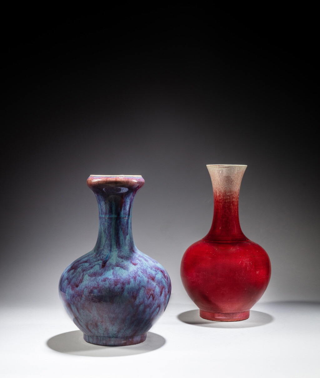 View full screen - View 1 of Lot 17. A flambé-glazed garlic-mouth vase and a red-glazed vase, 19th / 20th century | 十九 / 二十世紀 窰變釉蒜頭瓶及郎窰紅釉瓶一組兩件.