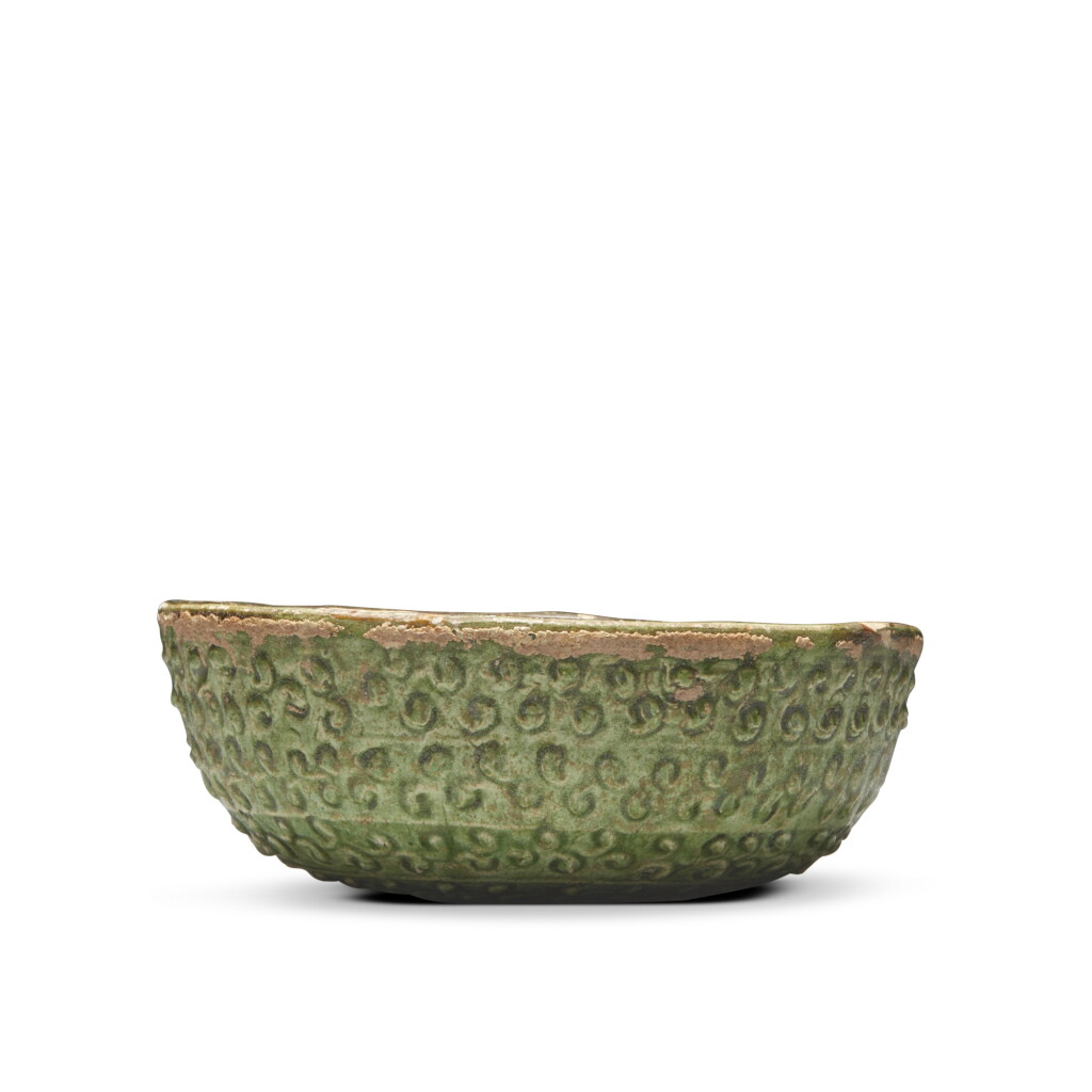 View full screen - View 1 of Lot 65. A molded amber- and green-glazed pottery bowl, Tang dynasty.