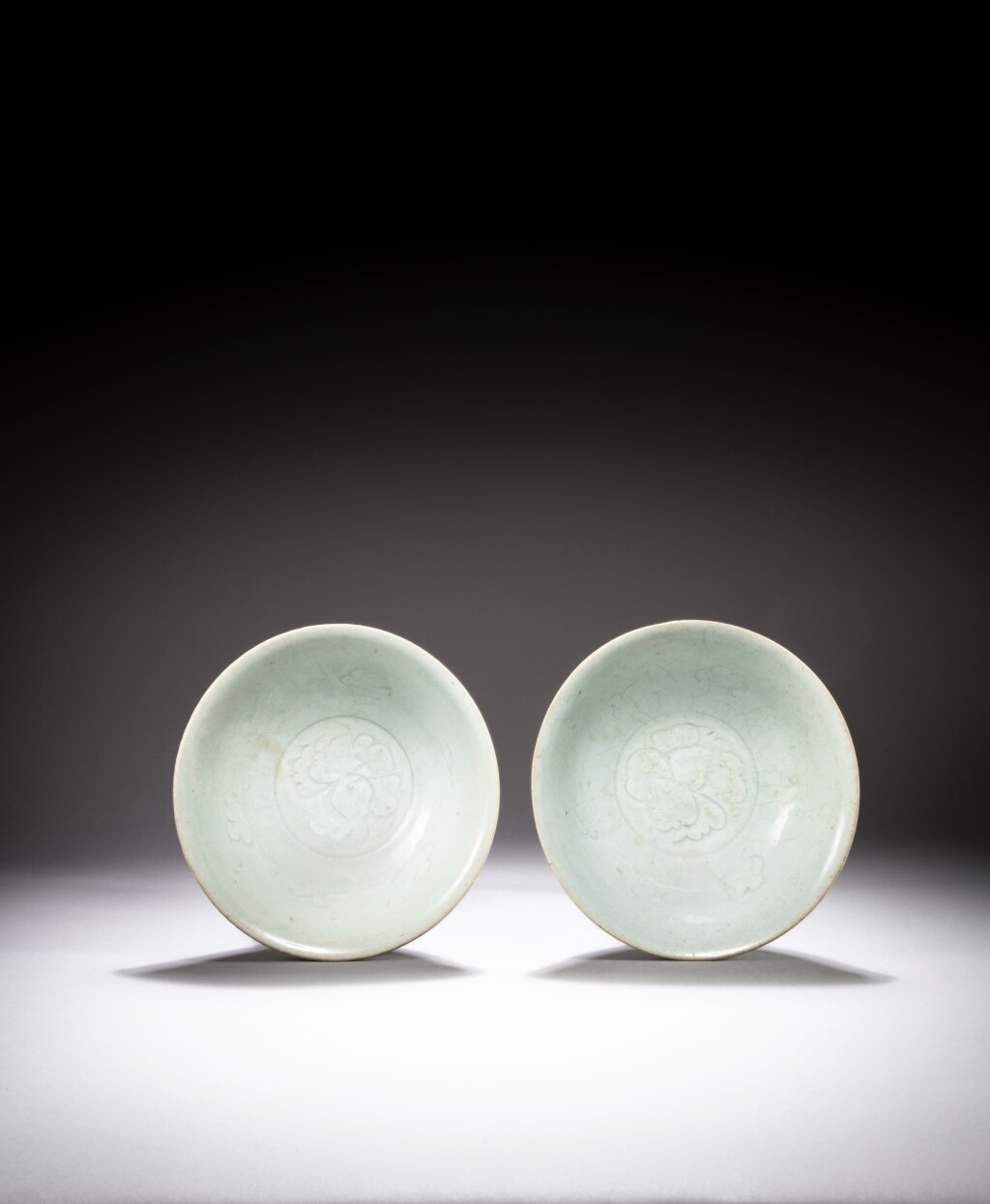 View full screen - View 1 of Lot 26. A pair of carved Qingbai 'floral' bowls, Song dynasty | 南宋 青白釉刻花卉紋盌一對.