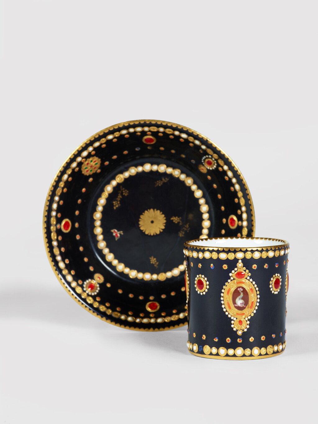 View full screen - View 1 of Lot 343. A Sèvres Porcelain 'Jeweled' Black-Ground 'Dauphin' Cup and Saucer (Gobelet litron et soucoupe), circa 1781.