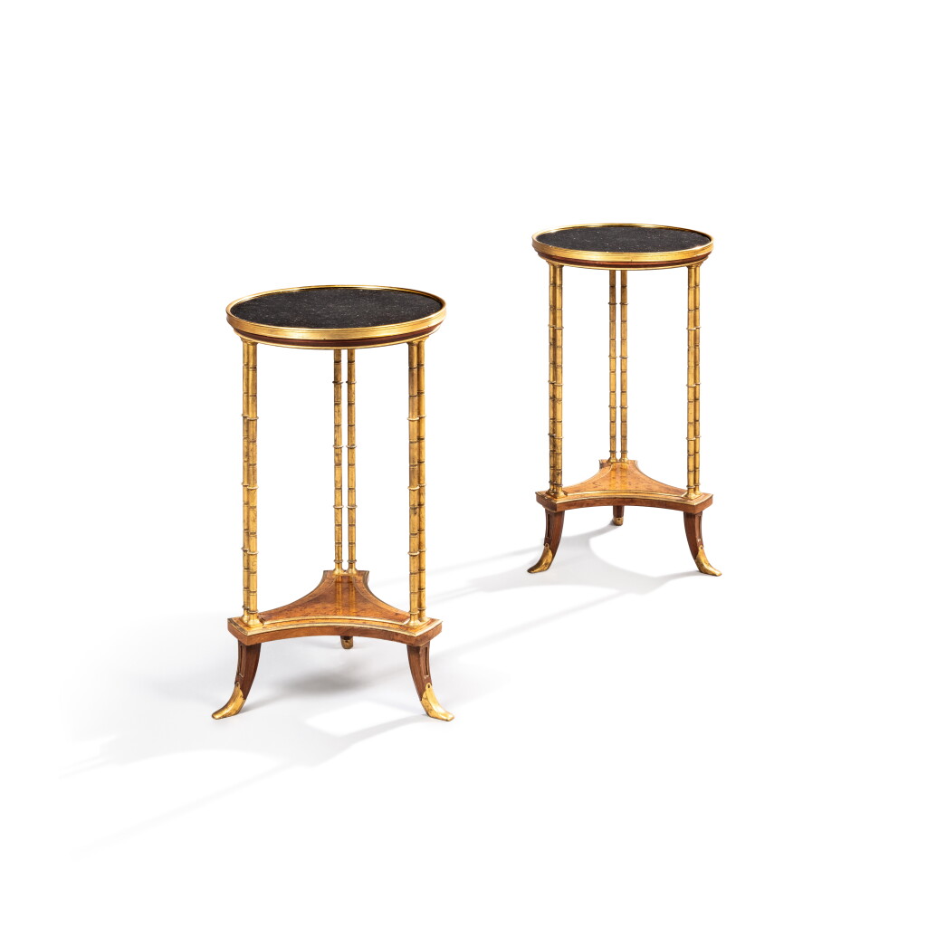 View full screen - View 1 of Lot 428. A pair of French gilt-bronze mounted mahogany and elm burl veneered guéridons, mid-20th century, after a model by Adam Weisweiler.