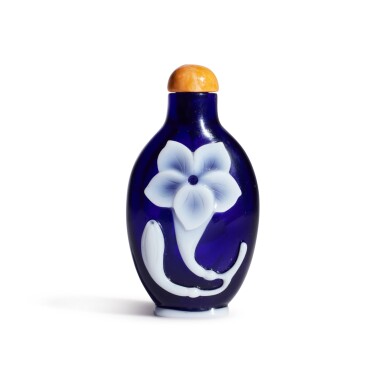 View full screen - View 1 of Lot 581. A white overlay cobalt-blue glass 'lily' snuff bottle, Qing dynasty, Qianlong period | 清乾隆 藍地套白料萱花紋鼻煙壺 .