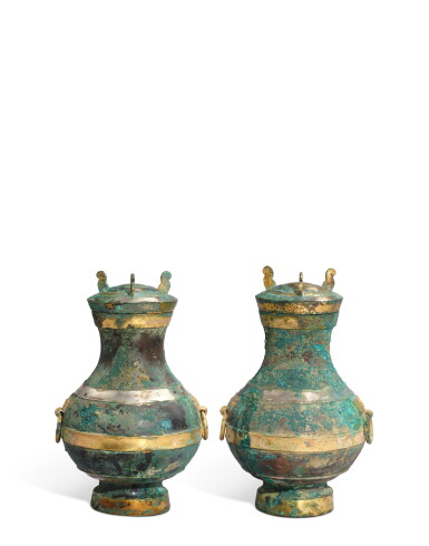 View full screen - View 1 of Lot 5113. A pair of parcel-gilt and silvered bronze vases, hu, Western Han dynasty | 西漢 青銅局部鎏金舖首銜環壺一對.