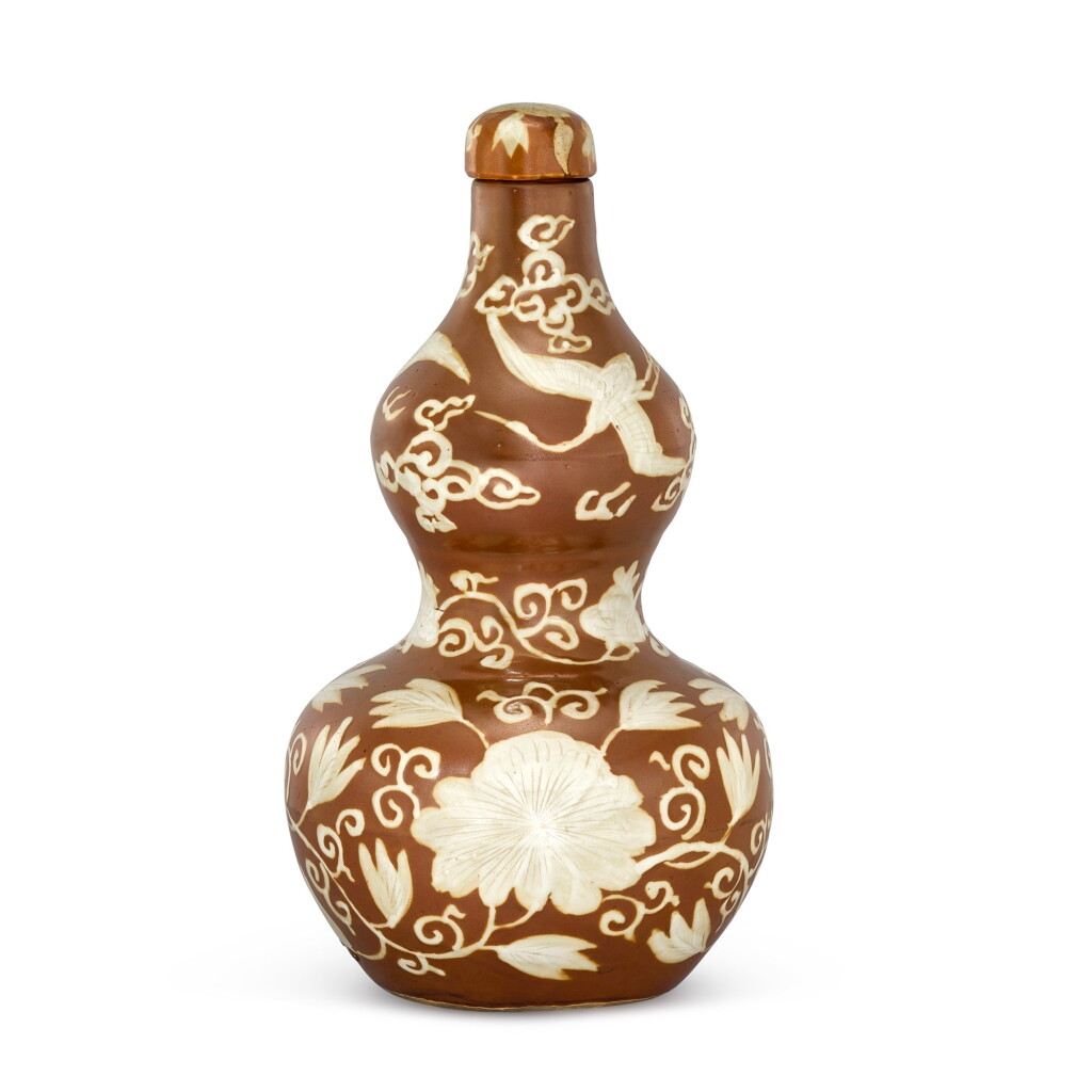 View full screen - View 1 of Lot 436. A RARE PERSIMMON-GROUND REVERSE-DECORATED 'CRANE' DOUBLE-GOURD VASE AND COVER MING DYNASTY, JIAJING PERIOD | 明嘉靖 醬釉留白花卉仙鶴紋葫蘆蓋瓶.