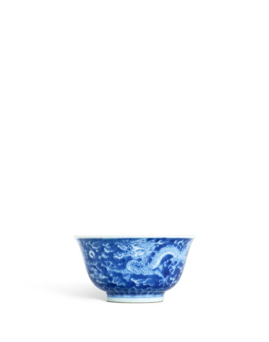 Voir en plein écran - Voir 1 du lot 3629. A fine blue and white reverse-decorated 'dragon' bowl, Mark and period of Kangxi | 清康熙 青花藍地白花雲龍紋盌 《大清康熙年製》款.