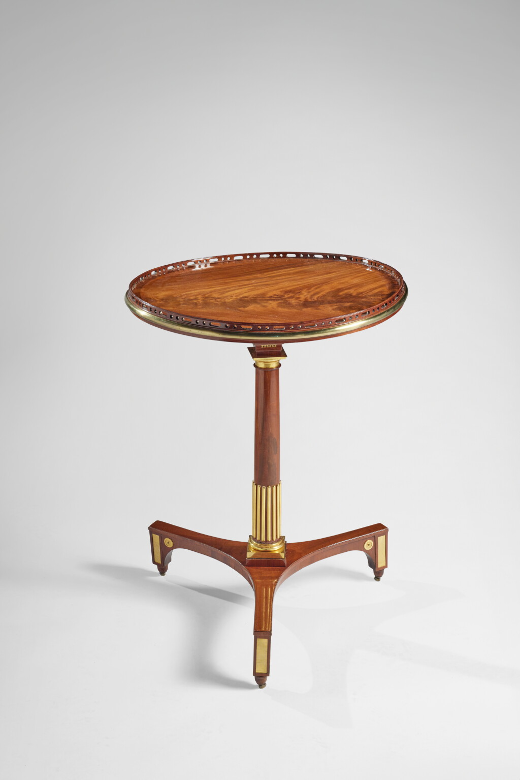 View full screen - View 1 of Lot 207. A German Neoclassical GIlt Bronze and Brass Mounted Mahogany Tripod Table by David Roentgen, Circa 1785.