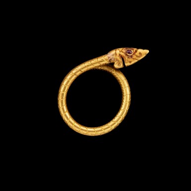 View full screen - View 1 of Lot 1047. A gold 'snake' ring set with ruby eyes Northern Thailand, 18th century or earlier | 十八世紀或更早 泰北 紅寶石蛇眼戒指.