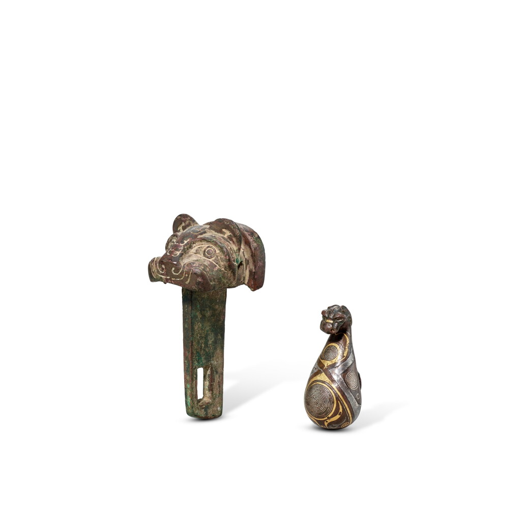 View full screen - View 1 of Lot 3596. A bronze 'tiger' chariot fitting and a gold-inlaid bronze belt hook, Late Shang dynasty - Eastern Zhou dynasty, Warring States period | 商晚期 青銅虎首車轄 及 東周戰國 銅錯金螭龍帶鉤.