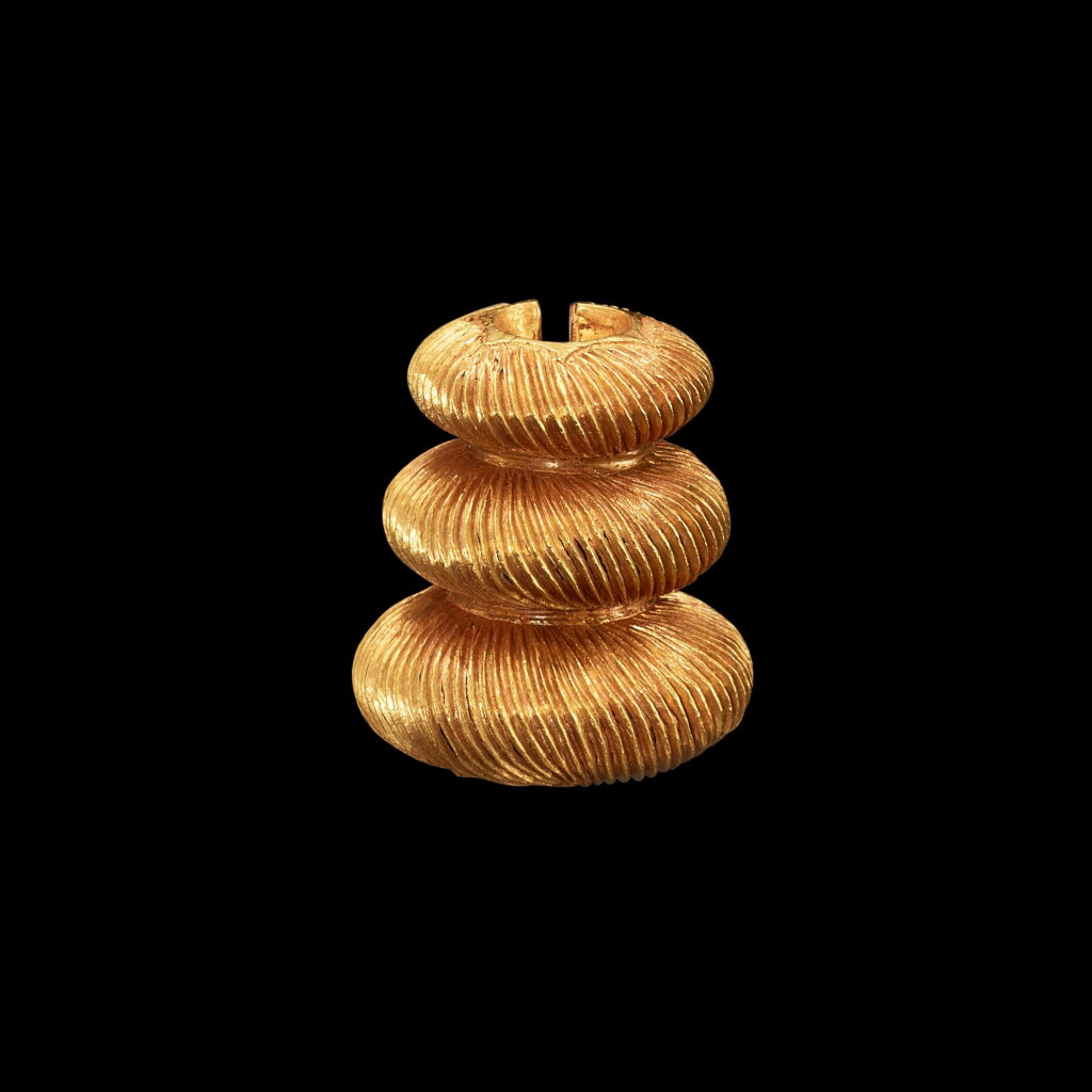 View full screen - View 1 of Lot 1071. A gold cord fastener with chiseled groves Java, Indonesia, 7th - 12th century | 印尼爪哇 七至十二世紀 三層雕刻金繩飾.