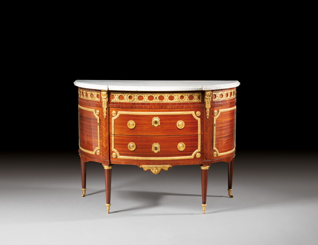 View full screen - View 1 of Lot 118. A Louis XVI satiné and gilt-bronze mounted commode demi-lune, attributed to Charles Topino | Commode demi-lune en placage de satiné et bronze doré d'époque Louis XVI, attribuée à Charles Topino.