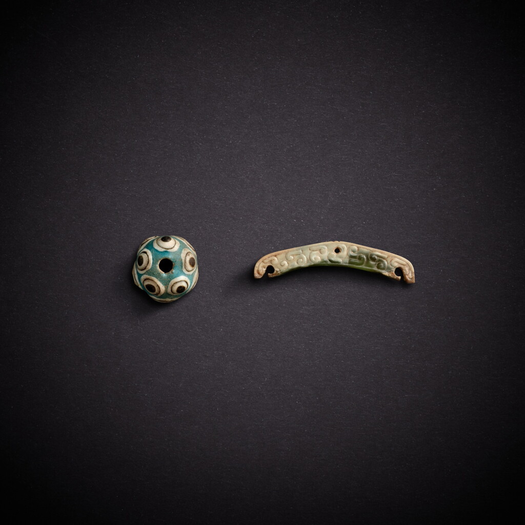 View full screen - View 1 of Lot 7869. A celadon jade pendant and a blue glass bead, Eastern Zhou dynasty, late Warring States period - Western Han dynasty | 東周戰國晚期至西漢 玉珮飾及琉璃珠飾.