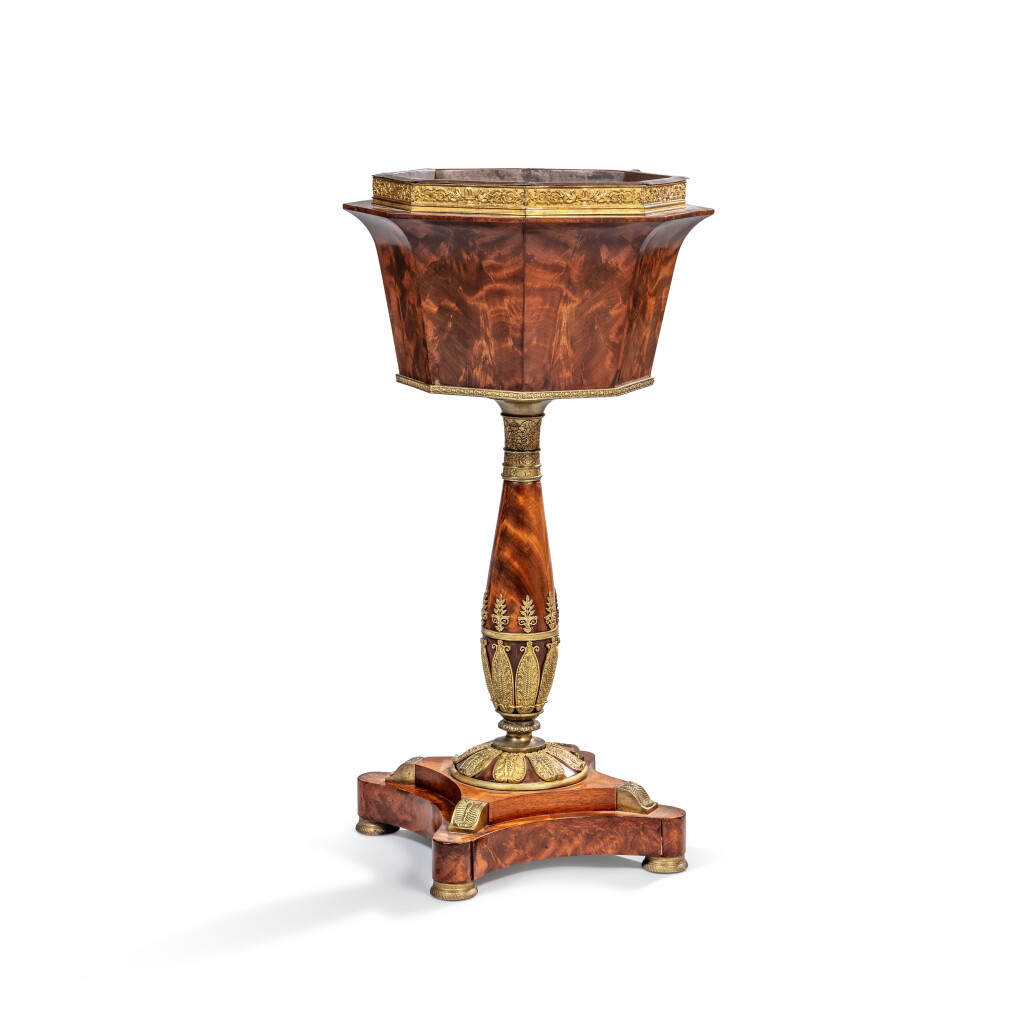 View full screen - View 1 of Lot 440. An Empire gilt-bronze mounted mahogany and plump pudding mahogany jardinière, circa 1810, attributed to Johannes Klinkerfuss.