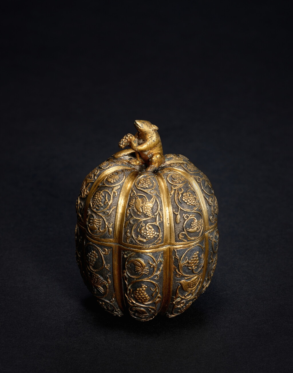 View full screen - View 1 of Lot 9809. An exquisite parcel-gilt silver 'squirrel and grape' melon-form box and cover, Tang dynasty, 7th - 8th century | 唐七至八世紀 局部鎏金銀葡萄松鼠瓜棱式蓋盒.