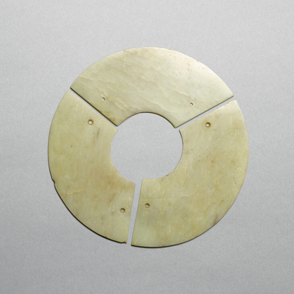 View full screen - View 1 of Lot 720. A pale celadon jade three-arc disc, bi, Neolithic period - early Shang dynasty | 新石器時代至商早期 青玉聯璜玉璧.