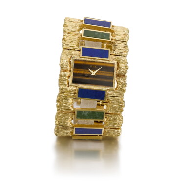 View full screen - View 1 of Lot 317. PIAGET | MANCHETTE REFERENCE 9212, YELLOW GOLD TIGER EYE LAPIZ LAZULI AND AGATE CUFF WATCH, CIRCA 1970.