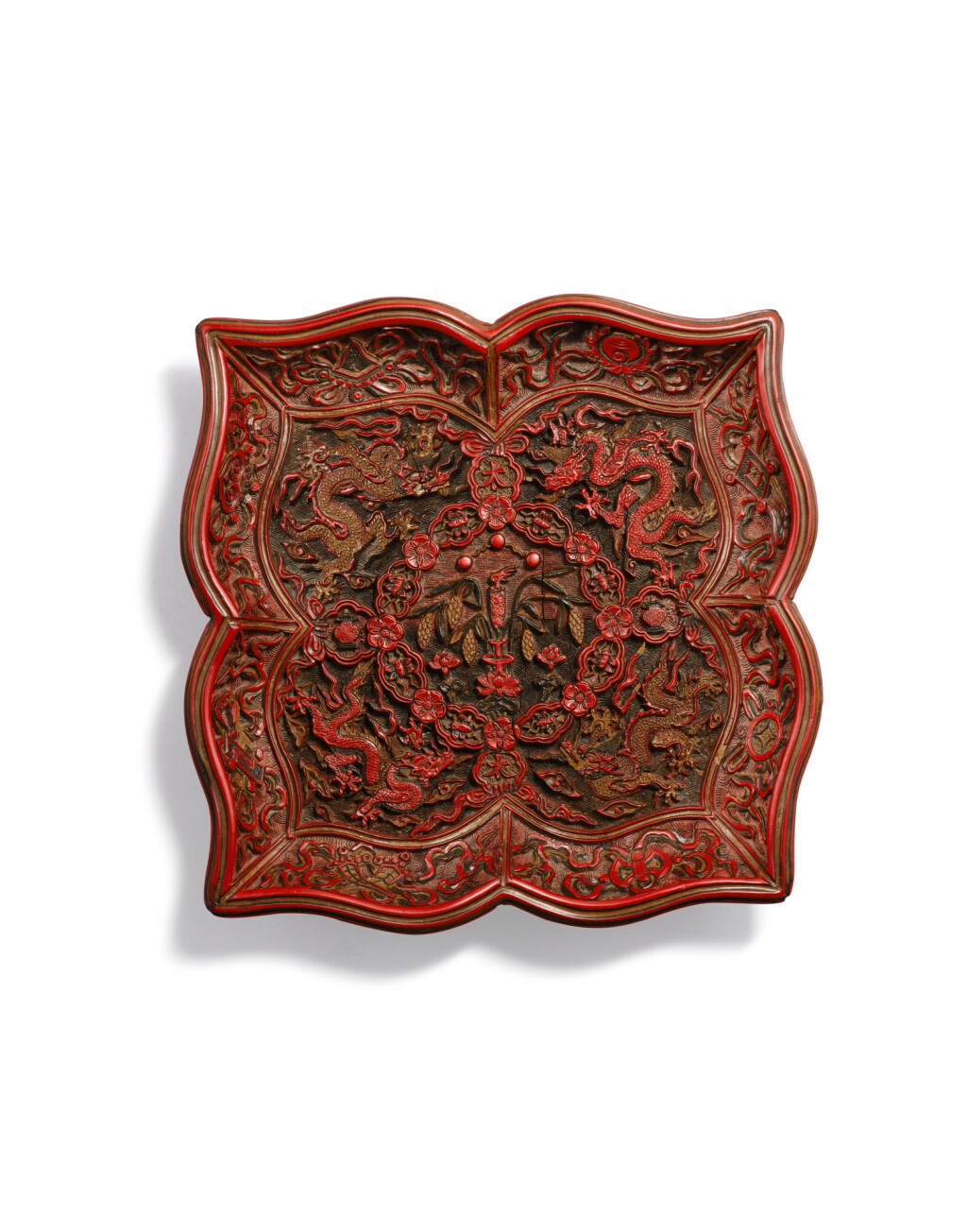 View full screen - View 1 of Lot 5077. A rare carved polychrome lacquer quatrefoil dish, Mark and period of Jiajing | 明嘉靖 剔彩龍紋菱花式盤 《大明嘉靖年製》款.