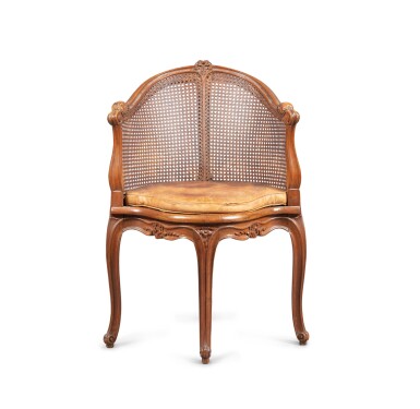 View full screen - View 1 of Lot 37. A Louis XV style caned and carved desk armchair | Fauteuil de bureau cané et sculpté, de style Louis XV.