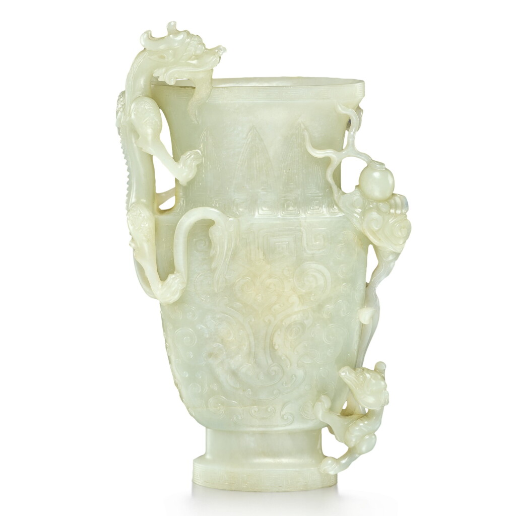 View full screen - View 1 of Lot 28. An archaistic pale celadon jade 'dragon' vase, Qing dynasty, 19th century | 清十九世紀 青白玉雕雙龍戲珠仿古饕餮紋瓶.