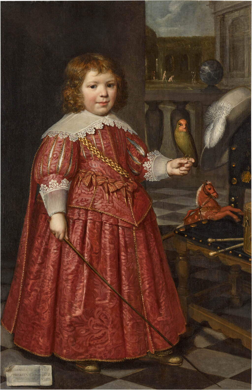 View full screen - View 1 of Lot 15. Portrait of Joannes de Ruyter (1627–1678), aged five, full-length, in a red costume, holding a red-cheeked parrot, with a hobby horse and drum and chair, a garden beyond.