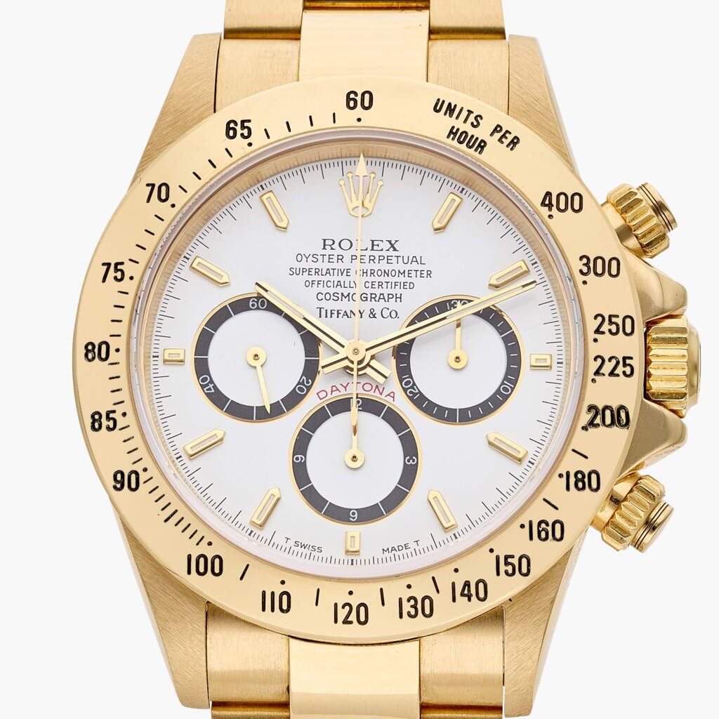 View full screen - View 1 of Lot 125. Reference 16528 Daytona ‘Inverted 6’ | Retailed by Tiffany & Co.: A yellow gold automatic chronograph wristwatch with bracelet, Circa 1989.